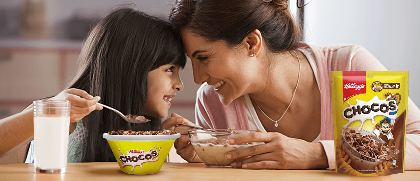 Mother and daughter having fun eating Kellogg's Chocos with a glass of milk