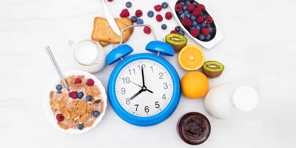 A healthy and balanced breakfast with a clock that displays the right breakfast time