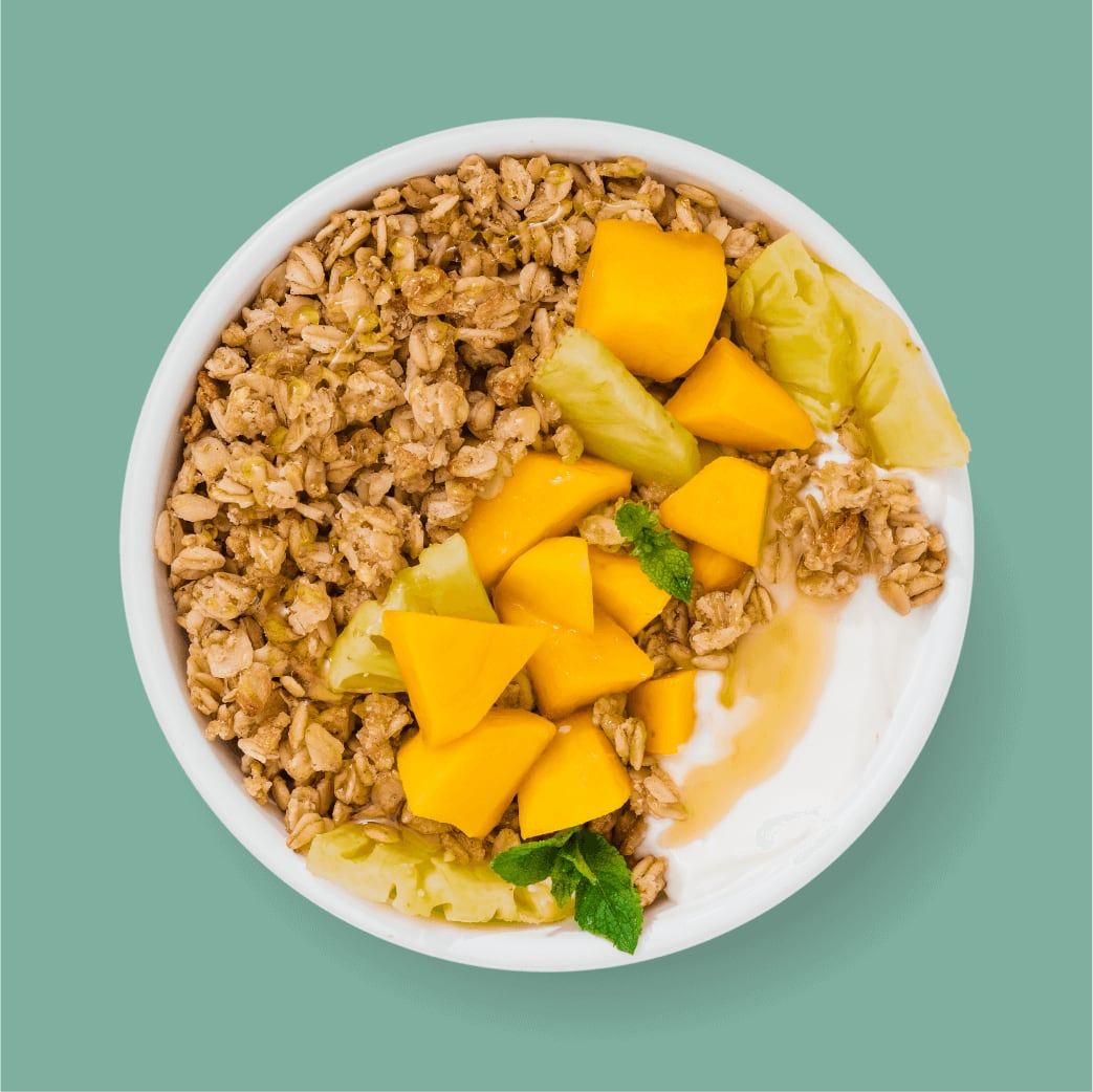 Bowl Of Kellogg's Granola with Yogurt, Mango, and fresh fruit pieces